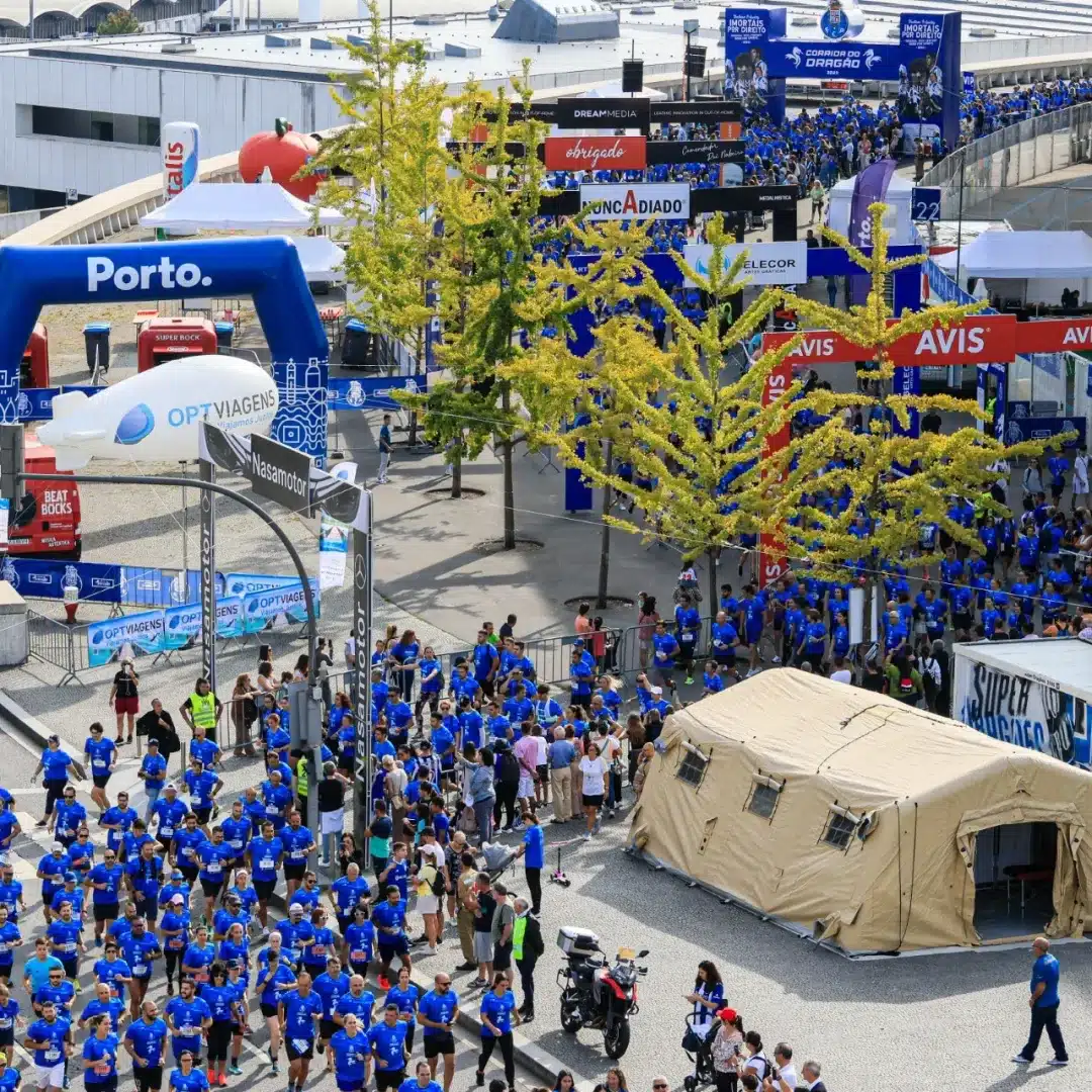 Imagem aérea de várias pessoas correndo em bloco a Corrida do Dragão, dentro da cidade.